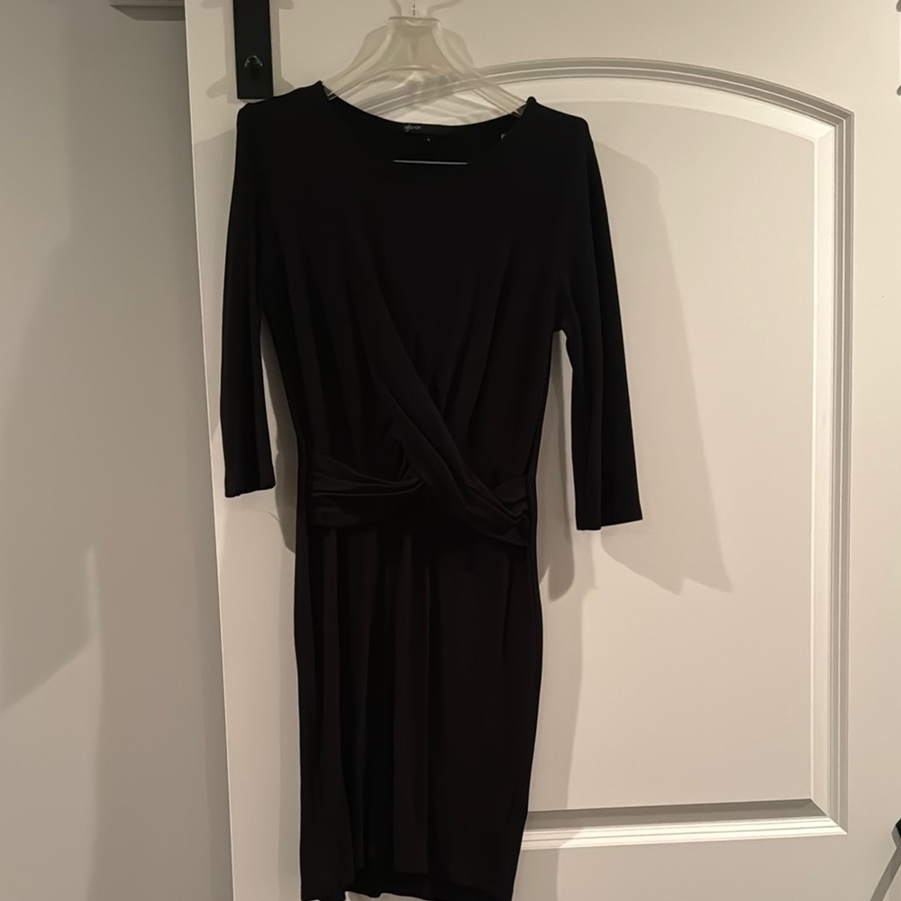Classic black knee length knit dress with wrap detail in front.